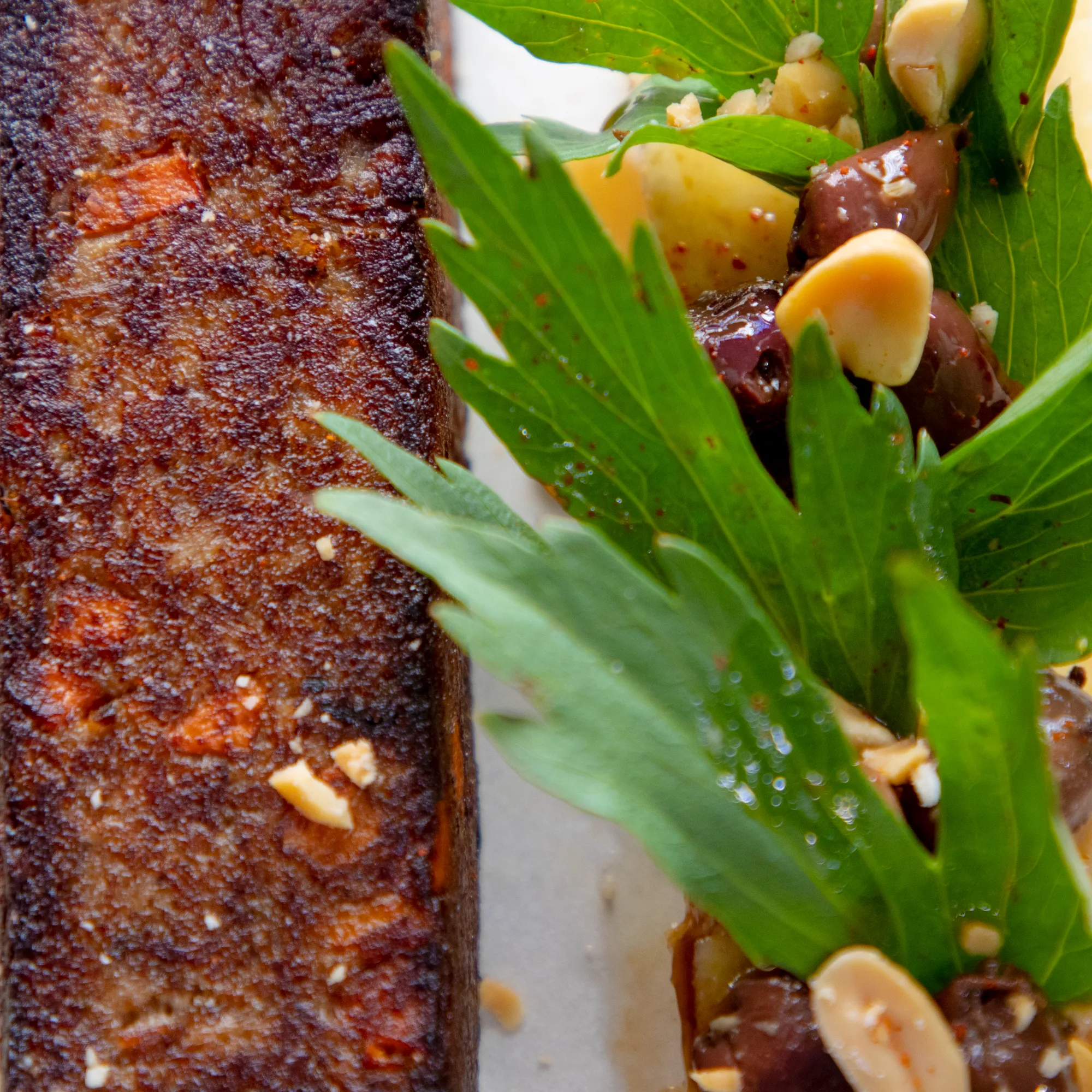 Peau de poisson rôtie, croustillante et caramélisée, dressée avec herbes fraîches, olives et amandes — cuisine bistronomique d'HABILE.