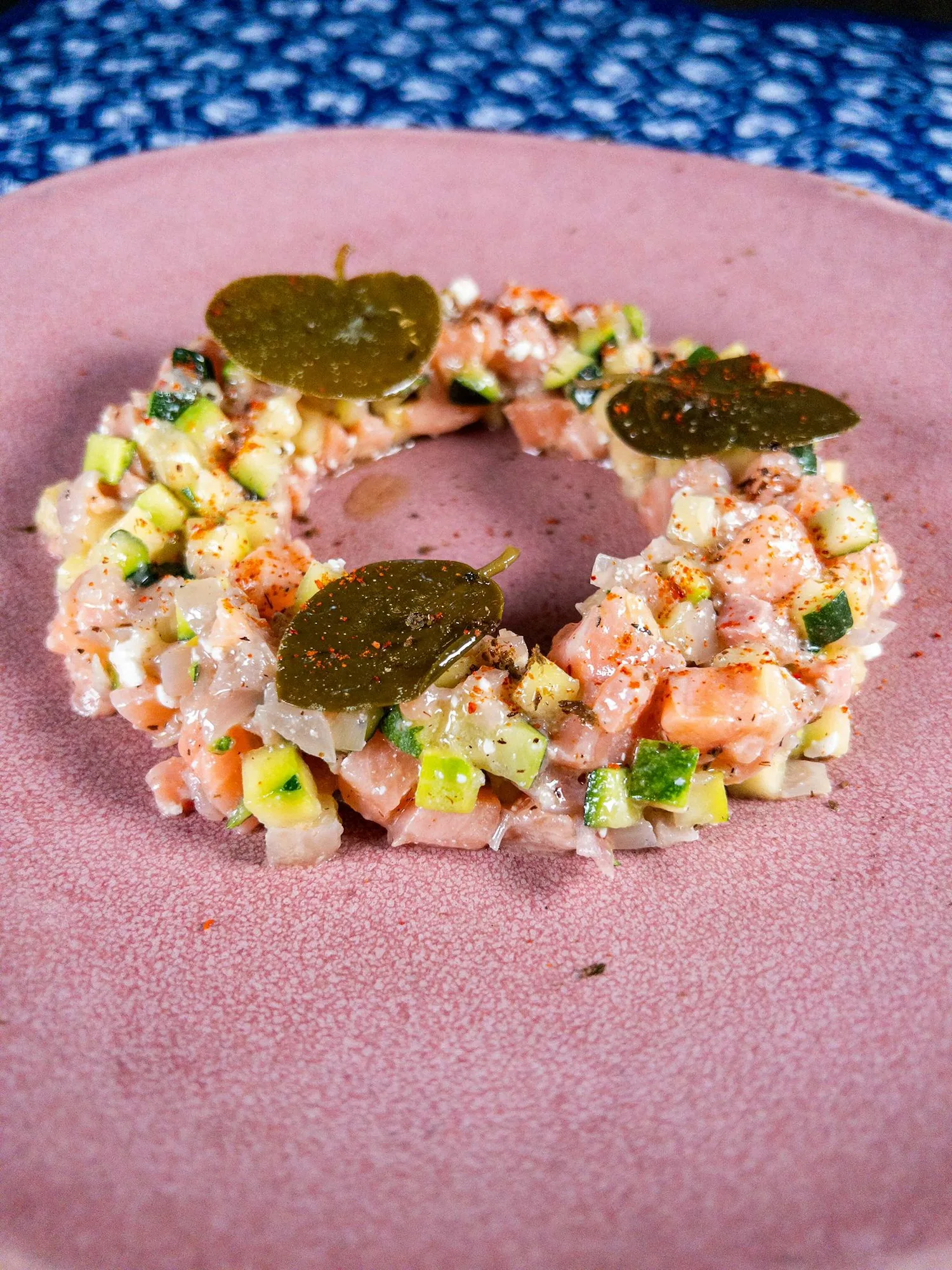 Tartare en couronne dressé sur assiette rose, brunoise de courgette et câpres, saupoudré de paprika — cuisine bistronomique HABILE.